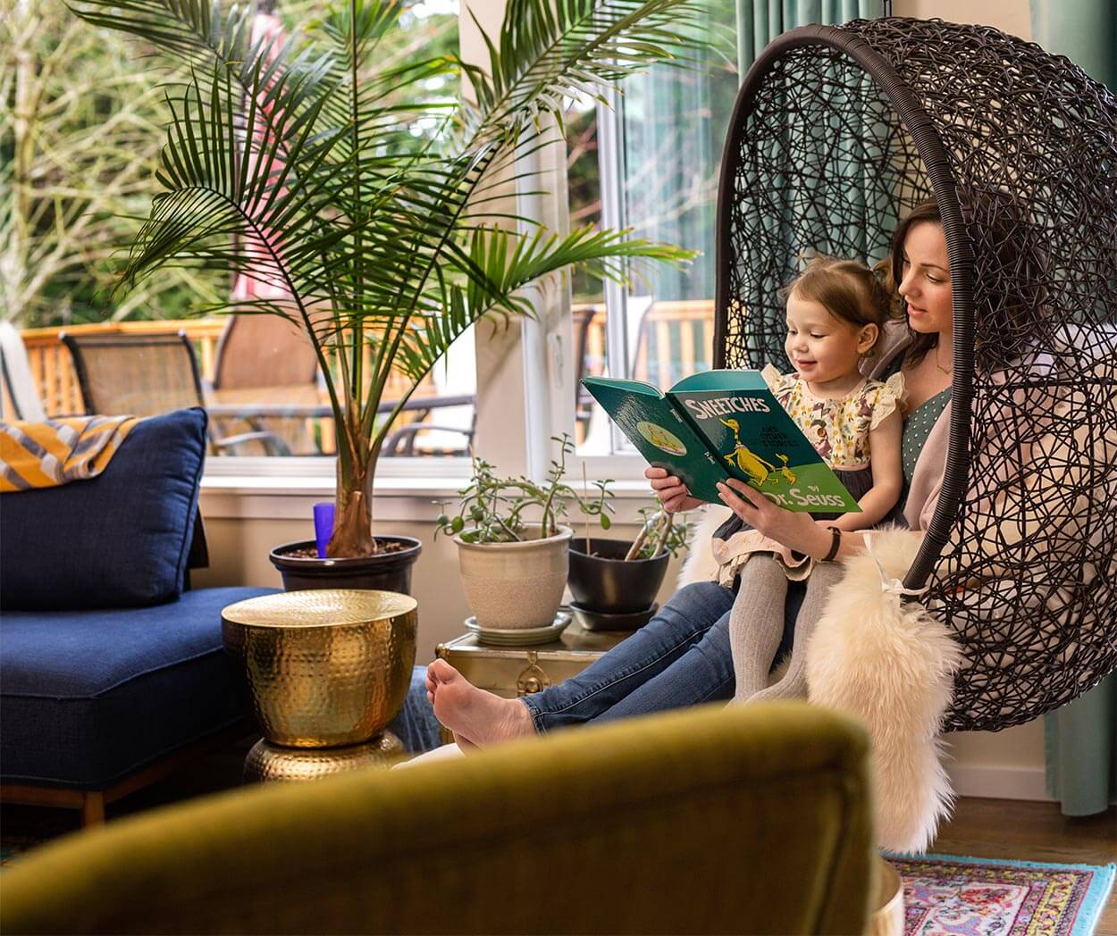 woman and child reading in a hanging chair