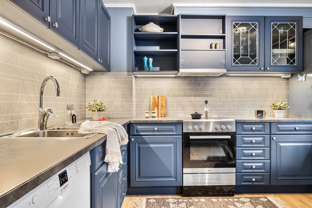 A kitchen with blue cabinets and a rug on the floor